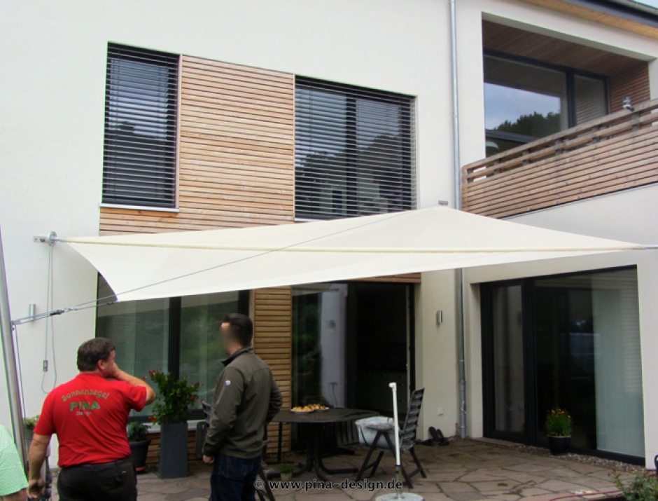 Sonnensegel manuell Bovenden 1M / 3W III.   in elfenbein vor einem Haus