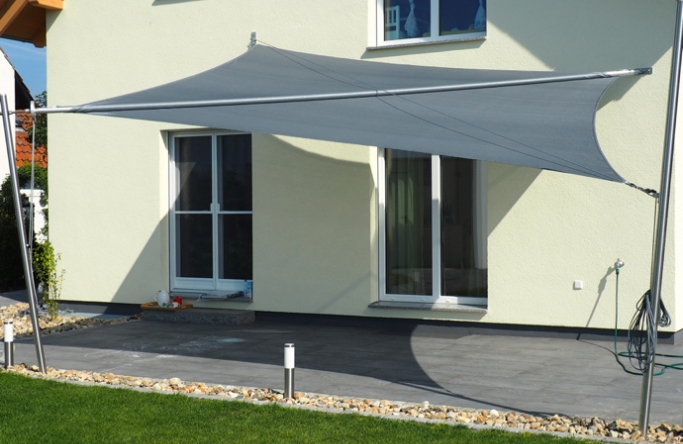 Sonnensegel manuell Uetze 2M / 2W I. anthrazites Segel vor einem Haus