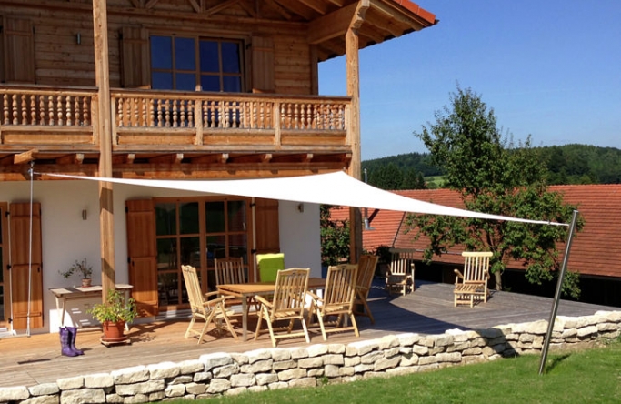 Sonnensegel an einer Terrasse in Bayern am Holzhaus