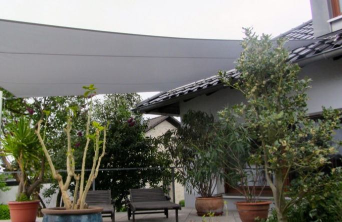 Sonnensegel feststehend Neuenrade 2M / 2W graues Segel vor einem weißen Haus