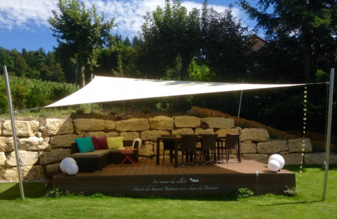 Sonnensegel feststehend Schweiz 4M in elfenbein über einer Gartenterrasse